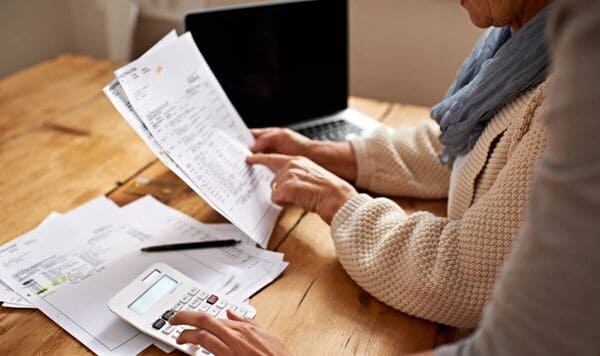 Persona revisando presupuesto con papeles y calculadora